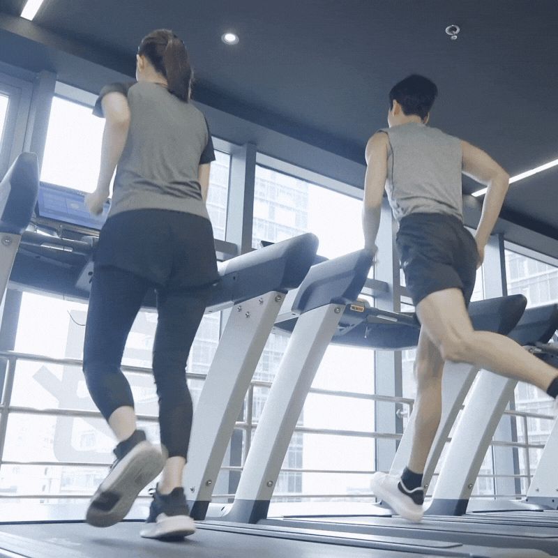 ジムでトレッドミルを使う女性